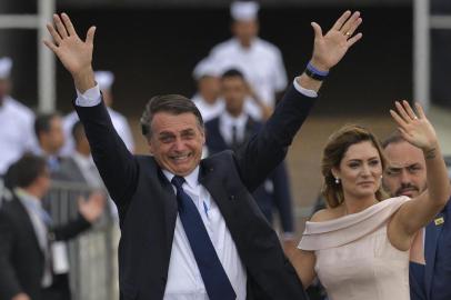  Brazils President-elect Jair Bolsonaro (L) gestures next to his wife Michelle Bolsonaro as the presidential convoy heads to the National Congress for his swearing-in ceremony, in Brasilia on January 1, 2019. - Bolsonaro takes office with promises to radically change the path taken by Latin Americas biggest country by trashing decades of centre-left policies. (Photo by Carl DE SOUZA / AFP)Editoria: POLLocal: BrasíliaIndexador: CARL DE SOUZASecao: governmentFonte: AFPFotógrafo: STF