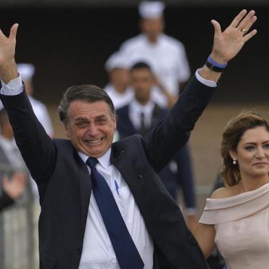  Brazils President-elect Jair Bolsonaro (L) gestures next to his wife Michelle Bolsonaro as the presidential convoy heads to the National Congress for his swearing-in ceremony, in Brasilia on January 1, 2019. - Bolsonaro takes office with promises to radically change the path taken by Latin Americas biggest country by trashing decades of centre-left policies. (Photo by Carl DE SOUZA / AFP)Editoria: POLLocal: BrasíliaIndexador: CARL DE SOUZASecao: governmentFonte: AFPFotógrafo: STF