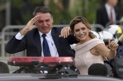  Brazils President-elect Jair Bolsonaro (L) gestures next to his wife Michelle Bolsonaro as the presidential convoy heads to the National Congress for his swearing-in ceremony, in Brasilia on January 1, 2019. - Bolsonaro takes office with promises to radically change the path taken by Latin Americas biggest country by trashing decades of centre-left policies. (Photo by Carl DE SOUZA / AFP)Editoria: POLLocal: BrasíliaIndexador: CARL DE SOUZASecao: governmentFonte: AFPFotógrafo: STF