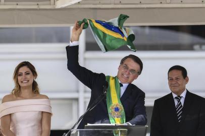  Brazil's new President Jair Bolsonaro (C) waves a Brazilian national flag next to First Lady Michelle Bolsonaro (L) and Brazil's new Vice-President Hamilton Mourao, during their inauguration ceremony at Planalto Palace in Brasilia on January 1, 2019. - Bolsonaro takes office with promises to radically change the path taken by Latin America's biggest country by trashing decades of centre-left policies. (Photo by EVARISTO SA / various sources / AFP)Editoria: POLLocal: BrasíliaIndexador: EVARISTO SASecao: governmentFonte: EVARISTO SAFotógrafo: STF