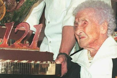 (FILES) In this file photo taken on February 21, 1996  Jeanne Calment, French pensioner and the worlds oldest person, looks at her birthday cake upon turning 121 years old during a ceremony held in her honour at Arles City Hall in the southern France. - What if Jeanne Calments longevity record was a fraud? Russian researchers have concluded an incredible sleight of hand between the French woman and her daughter, provoking interest and controversy in the scientific community. Jeanne Calment died at the age of 122 years and 164 days in 1997 - a world record of longevity of all genders. (Photo by Georges GOBET / AFP)