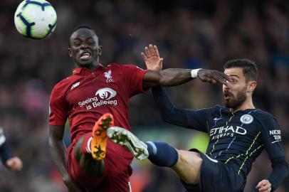 Liverpools Senegalese striker Sadio Mane (L) vies with Manchester Citys Portuguese midfielder Bernardo Silva during the English Premier League football match between Liverpool and Manchester City at Anfield in Liverpool, north west England on October 7, 2018. / AFP PHOTO / Paul ELLIS / RESTRICTED TO EDITORIAL USE. No use with unauthorized audio, video, data, fixture lists, club/league logos or live services. Online in-match use limited to 120 images. An additional 40 images may be used in extra time. No video emulation. Social media in-match use limited to 120 images. An additional 40 images may be used in extra time. No use in betting publications, games or single club/league/player publications. / 