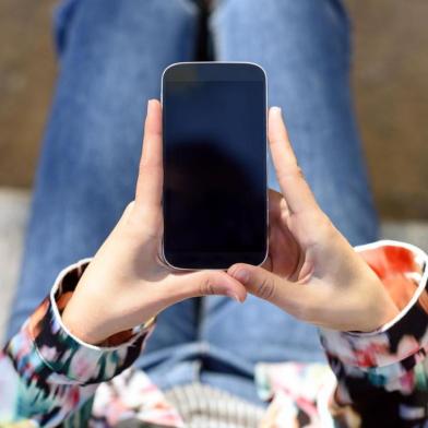 Mulher usando o celular. Foto para a coluna de Cris silva do dia 4 de janeiro de 2019