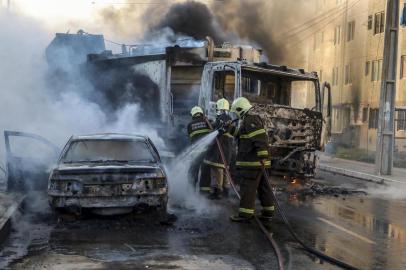 This picture released by O Povo shows firefighters putting out a burning truck and car during a wave of gang violence in Brazils northeastern Ceara state, in the Conjunto Palmeiras neighborhood, city of Fortaleza, Ceara state, Brazil on January 3, 2019. - Brazils government ordered troops to the northeast of the country on Friday to contain violence by criminal groups in the first test of new far-right President Jair Bolsonaros hardline law-and-order platform. (Photo by Alex GOMES / O Povo / AFP) / RESTRICTED TO EDITORIAL USE - MANDATORY CREDIT AFP PHOTO / O POVO / ALEX GOMES - NO MARKETING NO ADVERTISING CAMPAIGNS - DISTRIBUTED AS A SERVICE TO CLIENTS