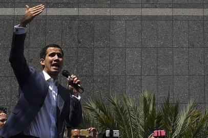  The president of Venezuelas opposition-led National Assembly Juan Guaido speaks to the crowd during an extraordinary open meeting in front of the headquarters of the United Nations Development Programme (UNDP) in Caracas on January 11, 2019. - Venezuelan President Nicolas Maduro began a new term on Thursday, with the economy in ruins and his regime more isolated than ever as regional leaders declared his re-election illegitimate and shunned his inauguration. (Photo by Yuri CORTEZ / AFP)Editoria: POLLocal: CaracasIndexador: YURI CORTEZSecao: governmentFonte: AFPFotógrafo: STF