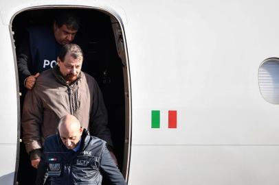  Italian former communist militant Cesare Battisti (C-L), wanted in Rome for four murders attributed to a far-left group in the 1970s, is escorted by Italian Police officers as he steps off a plane coming from Bolivia and chartered by Italian authorities, after landing at Ciampino airport in Rome on January 14, 2019. - Former communist militant Cesare Battisti landed in Rome on January 14 after an international police squad tracked the Italian down and arrested him in Bolivia, ending almost four decades on the run. (Photo by Alberto PIZZOLI / AFP)Editoria: POLLocal: RomeIndexador: ALBERTO PIZZOLISecao: politics (general)Fonte: AFPFotógrafo: STF