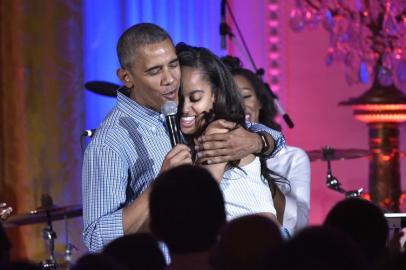 US President Barack Obama hugs his daughter Malia on her birthday during an Independence D