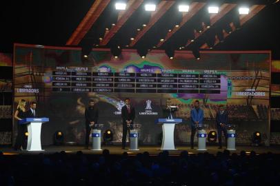 Conmebol Competitions director Frederico Nantes (C), next to Paraguayan footballers Santiago Salcedo (L) and Roque Santa Cruz (2nd-L) and Colombian footballers Miguel Borja (2nd-R) and Wilson Morelos (R), shows the name of Brazilian team Gremio during the 2018 Copa Libertadores round of 16 draw in Luque, Paraguay on June 4, 2018. (Photo by NORBERTO DUARTE / AFP)