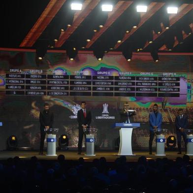 Conmebol Competitions director Frederico Nantes (C), next to Paraguayan footballers Santiago Salcedo (L) and Roque Santa Cruz (2nd-L) and Colombian footballers Miguel Borja (2nd-R) and Wilson Morelos (R), shows the name of Brazilian team Gremio during the 2018 Copa Libertadores round of 16 draw in Luque, Paraguay on June 4, 2018. (Photo by NORBERTO DUARTE / AFP)