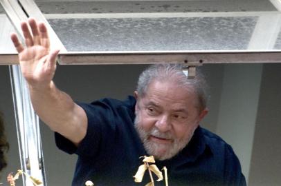  Former Brazilian President Luiz Inacio Lula da Silva (R) waves at supporters from a window of the Workers Party (PT) state headquarters in Sao Paulo, Brazil, on March 4, 2016. Police searched the home of Brazils powerful ex-president Luiz Inacio Lula da Silva and detained him for questioning Friday in a probe into a huge corruption scheme. The detention of Lula da Silva for questioning and the search of his home by officers probing a corruption network amounts to an attack on the rule of law, his spokesman said Friday. AFP PHOTO / NELSON ALMEIDA NELSON ALMEIDA / AFPEditoria: CLJLocal: Sao PauloIndexador: NELSON ALMEIDASecao: policeFonte: AFPFotógrafo: STF