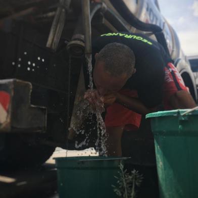 Sem água, moradores formam filas para encher baldes e galões em caminhões pipa na Lomba do Pinheiro. 