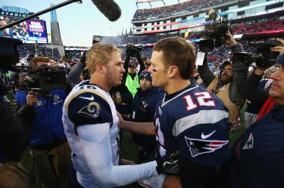 (FILES) In this file photo Jared Goff #16 (L) of the Los Angeles Rams greets Tom Brady #12 (R) of the New England Patriots after the New England Patriots defeated the Los Angeles Rams 26-10 at Gillette Stadium on December 4, 2016 in Foxboro, Massachusetts. Tom Brady will chase a record-breaking sixth Super Bowl crown here on Sunday as the New England Patriots take on the Los Angeles Rams in a clash of the generations set to rewrite NFL history. Brady, 41, will become the oldest quarterback ever to lift the title if he masterminds yet another championship in the latest milestone of a career that has shown no signs of flagging. Records are also set to tumble in the event of a win by the youthful Los Angeles Rams, who are led by 24-year-old quarterback Jared Goff and head coaching prodigy Sean McVay.