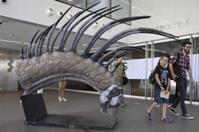 People walk past a replica of a Bajadasaurus pronuspinax, a new long-spined dinosaur found in Patagonia, during its presentation in Buenos Aires, on February 4, 2019. (Photo by Juan MABROMATA / AFP)