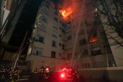 This handout picture taken and released by the Paris firefighters brigade (BSPP) in the night of February 5, 2019 shows firemen spraying water as a fire burns in a building in Erlanger street in the 16th arrondissement in Paris. - A woman has been arrested over a deadly blaze that killed eight people in Paris and police are treating the fire as a possible arson attack, a prosecutor said early on February 5. (Photo by Benoît Moser / BSPP - Brigade de sapeurs-pompiers de Paris / AFP) / RESTRICTED TO EDITORIAL USE - MANDATORY CREDIT AFP PHOTO / Benoît Moser / BSPP - NO MARKETING NO ADVERTISING CAMPAIGNS - DISTRIBUTED AS A SERVICE TO CLIENTS ---