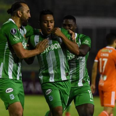 Colombias Atletico Nacional Sebastian Gomez (C) celebrates with his teammates Carlos Augusto Rivas (R) and Hernan Barcos, after scoring against Venezuelas Deportivo La Guaira, during their Copa Libertadores football match at the Olimpico stadium in Caracas on February 07, 2019 (Photo by JUAN BARRETO / AFP)