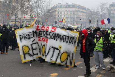 Protesters throw back tear gas canisters thrown by police at Place de la Republique on February 2, 2019 in Paris, on the sidelines of a march called to pacifically protest against police violence toward participants of the last three months demonstrations in France, as  yellow vest protesters take to the streets for the 12th consecutive Saturday. - The 'Yellow Vest' (Gilets Jaunes) movement in France originally started as a protest about planned fuel hikes but has morphed into a mass protest against President's policies and top-down style of governing. (Photo by Zakaria ABDELKAFI / AFP)