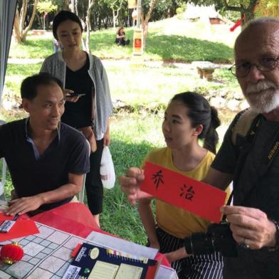 Jorge Aguiar mostra seu nome em caracteres chineses, durante evento em comemoração ao ano-novo chinês, na Redenção