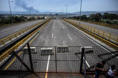 Containers block the Tienditas bridge, with a stage in the background -where a concert will take place on Saturday 23- in Urena, Venezuela, on the border with Colombia, on February 20, 2019. - Nicolas Maduros government suspended indefinite flights and set sail for Curaçao, Aruba and Bonaire, and announced the revision of relations with the three Caribbean islands in their offensive to prevent the entry of humanitarian aid to Venezuela on Saturday. (Photo by Juan BARRETO / AFP)