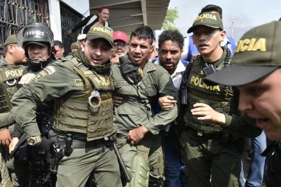 Colombian policemen accompany a Venezuelan police officer who deserted from Venezuela at the Simon Bolivar international bridge, in Cucuta, Colombia after President Nicolas Maduros government ordered to temporary close down the border with Colombia on February 23, 2019. - Venezuela braced for a showdown between the military and regime opponents at the Colombian border on Saturday, when self-declared acting president Juan Guaido has vowed humanitarian aid would enter his country despite a blockade. (Photo by Luis ROBAYO / AFP)