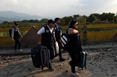  An employee (R) of the Colombian Consulate in Valencia, Venezuela, walks followed by the Colombian Consul in Merida, Venezuela, Carlos Garcia (2-R), as they cross the Simon Bolivar international bridge from San Antonio del Tachira, Venezuela, to Cucuta, Colombia, on February 24, 2019. - International pressure mounted against Venezuelas leader Nicolas Maduro, with Washington vowing to take action after opposition efforts to bring humanitarian aid into the country descended into bloody chaos. Maduro claims the aid is a smokescreen for a US invasion, and has ordered several crossings on Venezuelas borders with Colombia and Brazil closed. (Photo by Federico Parra / AFP)Editoria: WARLocal: San Antonio del TáchiraIndexador: FEDERICO PARRASecao: diplomacyFonte: AFPFotógrafo: STF