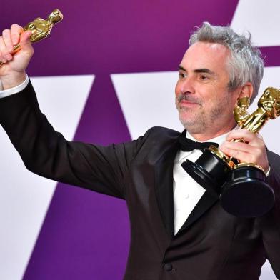 Best Director, Best Foreign Language Film, and Best Cinematography winner for Roma Alfonso Cuaron poses in the press room with his Oscars during the 91st Annual Academy Awards at the Dolby Theatre in Hollywood, California on February 24, 2019. (Photo by FREDERIC J. BROWN / AFP)