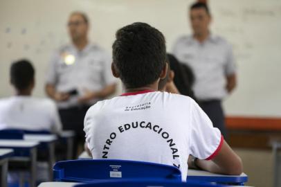 Students attend a class given by a police officer at the Education Center 07 of Ceilandia, near Brasilia which takes part in a pilot project of joint management between the Brazilian Secretariats of Education and Public Security, on February 12, 2019. - During his election campaign President Bolsonaro, a former paratrooper, promised to establish more of these state-run military secondary schools. By the end of the year, there should be around 40 education centers in which military police have been put in charge of discipline and administrative functions, while lessons are given by civilian teachers. (Photo by Sergio LIMA / AFP)