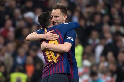 Barcelona's Argentinian forward Lionel Messi (L) celebrates with Barcelona's Croatian midfielder Ivan Rakitic at the end of the Spanish league football match between Real Madrid CF and FC Barcelona at the Santiago Bernabeu stadium in Madrid on March 2, 2019. 