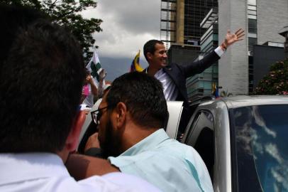 Venezuelan opposition leader and self-proclaimed acting president Juan Guaido greets supporters upon his arrival in Caracas on March 4, 2019. - Venezuelas opposition leader Juan Guaido was mobbed by supporters, media and the ambassadors of allied countries as he returned to Caracas on Monday, defying the threat of arrest from embattled President Nicolas Maduros regime. Just before his arrival, US Vice President Mike Pence sent a warning to Maduro to ensure Guaidos safety. (Photo by Yuri CORTEZ / AFP)