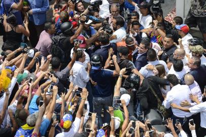 Venezuelan opposition leader and self-proclaimed acting president Juan Guaido (C-R) is greeted by supporters upon his arrival in Caracas on March 4, 2019. - Venezuelas opposition leader Juan Guaido was mobbed by supporters, media and the ambassadors of allied countries as he returned to Caracas on Monday, defying the threat of arrest from embattled President Nicolas Maduros regime. Just before his arrival, US Vice President Mike Pence sent a warning to Maduro to ensure Guaidos safety. (Photo by Matias DELACROIX / AFP)