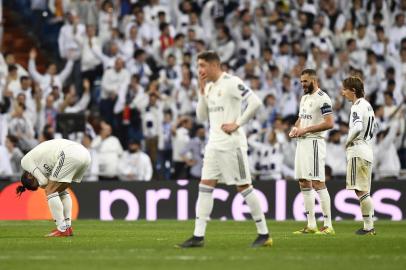 Real Madrids French forward Karim Benzema (2ndR) and Real Madrids Croatian midfielder Luka Modric (R) look at Real Madrids Welsh forward Gareth Bale (L) as he reacts in pain during the UEFA Champions League round of 16 second leg football match between Real Madrid CF and Ajax at the Santiago Bernabeu stadium in Madrid on March 5, 2019. (Photo by GABRIEL BOUYS / AFP)