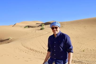 Ao sobrevoar Marraquesh, em Marrocos, ja se percebe um cenario uniforme de casas baixas, quadradas e cor de terra. Ficamos hospedados na Medina area murada antiga em um dos riads com arquitetura que isola som e temperatura com jardim central que ja mostra como o norte da Africa e, ao mesmo tempo, proximo e tao distante da Europa. Sao varias atracoes como palacios no meio do fervo da cidade, arquitetura peculiar com oliveiras centenarias e a praca Jemaa El Fna com encantadores de serpentes, dancarinos, contadores de historia e centenas de lojinhas de barganha souks. Partindo para o interior, as montanhas Atlas tem paisagens impressionantes, com pedras e neve. Uma parada importante é a cidade de Ait Ben Haddou, constituida por um grupo de varias pequenas fortalezas, ou casbas. O cenario vai ficando mais desertico em direçao a regiao do oasis de Skoura. Visitar o oasis inclui entender um sistema milenar de irrigacao comunitaria, uma combinacao incomum de sofisticacao e rusticidade e o dia a dia do morador local. Mais algumas horas em boas estradas, Merzouga e a porta do Deserto do Saara, quase na fronteira com a Argelia. Com dunas imensas, a experiencia de se hospedar em tendas, ir de camelo em pontos altos para ver por e o nascer do sol sao impactantes. A cor do ceu contrastando com a areia parece quase irreal. O pais e uma surpresa atras da outra e ilustra uma regiao que aprendeu a viver na adversidade. 