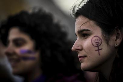 A woman with her face painted with the feminist hand symbol attends a demonstration marking International Womens Day in Lisbon on March 8, 2019. (Photo by PATRICIA DE MELO MOREIRA / AFP)