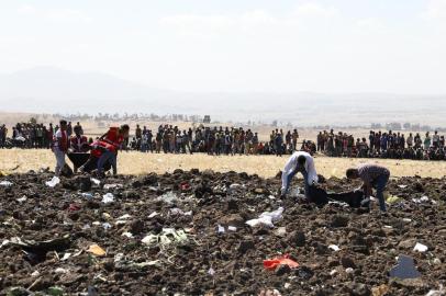 Rescue team collect remains of bodies amid debris at the crash site of Ethiopia Airlines near Bishoftu, a town some 60 kilometres southeast of Addis Ababa, Ethiopia, on March 10, 2019. - An Ethiopian Airlines Boeing 737 crashed on March 10 morning en route from Addis Ababa to Nairobi with 149 passengers and eight crew believed to be on board, Ethiopian Airlines said. (Photo by Michael TEWELDE / AFP)