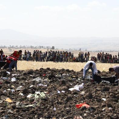 Rescue team collect remains of bodies amid debris at the crash site of Ethiopia Airlines near Bishoftu, a town some 60 kilometres southeast of Addis Ababa, Ethiopia, on March 10, 2019. - An Ethiopian Airlines Boeing 737 crashed on March 10 morning en route from Addis Ababa to Nairobi with 149 passengers and eight crew believed to be on board, Ethiopian Airlines said. (Photo by Michael TEWELDE / AFP)