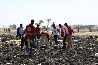 Red cross team work amid debris at the crash site of Ethiopia Airlines near Bishoftu, a town some 60 kilometres southeast of Addis Ababa, Ethiopia, on March 10, 2019. - An Ethiopian Airlines Boeing 737 crashed on March 10 morning en route from Addis Ababa to Nairobi with 149 passengers and eight crew believed to be on board, Ethiopian Airlines said. (Photo by Michael TEWELDE / AFP)