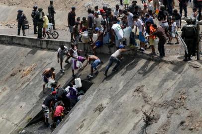  People collect water from a broken pipe, flowing into a sewage canal at the Guaire river in Caracas on March 11, 2019, as a massive power outage continues affecting some areas of the country. - Venezuelas opposition leader Juan Guaido will ask lawmakers on Monday to declare a state of alarm over the countrys devastating blackout in order to facilitate the delivery of international aid -- a chance to score points in his power struggle with President Nicolas Maduro. (Photo by Cristian HERNANDEZ / AFP) / The erroneous mention[s] appearing in the metadata of this photo by Cristian HERNANDEZ has been modified in AFP systems in the following manner: [collect water from a broken pipe, flowing into a sewage canal at the Guaire river ] instead of [collect water from a sewage canal at the river Guaire ]. Please immediately remove the erroneous mention[s] from all your online services and delete it (them) from your servers. If you have been authorized by AFP to distribute it (them) to third parties, please ensure that the same actions are carried out by them. Failure to promptly comply with these instructions will entail liability on your part for any continued or post notification usage. Therefore we thank you very much for all your attention and prompt action. We are sorry for the inconvenience this notification may cause and remain at your disposal for any further information you may require.Editoria: WARLocal: CaracasIndexador: CRISTIAN HERNANDEZSecao: crisisFonte: AFPFotógrafo: STR