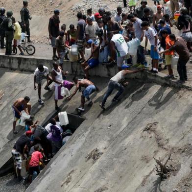  People collect water from a broken pipe, flowing into a sewage canal at the Guaire river in Caracas on March 11, 2019, as a massive power outage continues affecting some areas of the country. - Venezuelas opposition leader Juan Guaido will ask lawmakers on Monday to declare a state of alarm over the countrys devastating blackout in order to facilitate the delivery of international aid -- a chance to score points in his power struggle with President Nicolas Maduro. (Photo by Cristian HERNANDEZ / AFP) / The erroneous mention[s] appearing in the metadata of this photo by Cristian HERNANDEZ has been modified in AFP systems in the following manner: [collect water from a broken pipe, flowing into a sewage canal at the Guaire river ] instead of [collect water from a sewage canal at the river Guaire ]. Please immediately remove the erroneous mention[s] from all your online services and delete it (them) from your servers. If you have been authorized by AFP to distribute it (them) to third parties, please ensure that the same actions are carried out by them. Failure to promptly comply with these instructions will entail liability on your part for any continued or post notification usage. Therefore we thank you very much for all your attention and prompt action. We are sorry for the inconvenience this notification may cause and remain at your disposal for any further information you may require.Editoria: WARLocal: CaracasIndexador: CRISTIAN HERNANDEZSecao: crisisFonte: AFPFotógrafo: STR