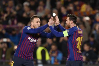 Barcelonas Argentinian forward Lionel Messi (R) celebrates with Barcelonas Brazilian midfielder Arthur after scoring during the UEFA Champions League round of 16, second leg football match between FC Barcelona and Olympique Lyonnais at the Camp Nou stadium in Barcelona on March 13, 2019. (Photo by Josep LAGO / AFP)