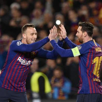 Barcelona's Argentinian forward Lionel Messi (R) celebrates with Barcelona's Brazilian midfielder Arthur after scoring during the UEFA Champions League round of 16, second leg football match between FC Barcelona and Olympique Lyonnais at the Camp Nou stadium in Barcelona on March 13, 2019. (Photo by Josep LAGO / AFP)