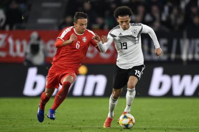  Germanys midfielder Leroy Sane (R) vies with Serbias midfielder Nemanja Maksimovic during the friendly football match Germany v Serbia in Wolfsburg, western Germany on March 20, 2019. (Photo by John MACDOUGALL / AFP) / RESTRICTIONS: ACCORDING TO DFB RULES IMAGE SEQUENCES TO SIMULATE VIDEO IS NOT ALLOWED DURING MATCH TIME. MOBILE (MMS) USE IS NOT ALLOWED DURING AND FOR FURTHER TWO HOURS AFTER THE MATCH. == RESTRICTED TO EDITORIAL USE == FOR MORE INFORMATION CONTACT DFB DIRECTLY AT +49 69 67880 / Editoria: SPOLocal: WolfsburgIndexador: JOHN MACDOUGALLSecao: soccerFonte: AFPFotógrafo: STF