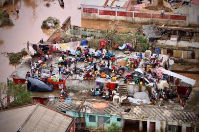 People gather on the roof of a house submerged by floods in Buzi on March 20, 2019. - International aid agencies raced on March 20 to rescue survivors and meet spiralling humanitarian needs in three impoverished countries battered by one of the worst storms to hit southern Africa in decades. Five days after tropical cyclone Idai cut a swathe through Mozambique, Zimbabwe and Malawi, the confirmed death toll stood at more than 300 and hundreds of thousands of lives were at risk, officials said. (Photo by ADRIEN BARBIER / AFP)