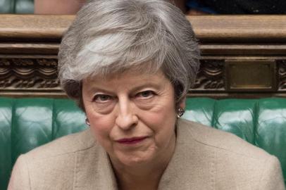 A handout photograph taken and released by the UK Parliament on March 29, 2019 shows Britains Prime Minister Theresa May listening to a speaker during a a debate in the House of Commons on the Governments Withdrawal Agreement Bill, before MPs voted on it. - British MPs on Friday rejected Prime Minister Theresa Mays EU divorce deal for a third time, opening the way for a long delay to Brexit -- or a potentially catastophic no deal withdrawal in two weeks. (Photo by MARK DUFFY / UK PARLIAMENT / AFP) / EDITORS NOTE THE IMAGE HAS BEEN DIGITALLY ALTERED AT SOURCE TO OBSCURE VISIBLE DOCUMENTS  - RESTRICTED TO EDITORIAL USE - NO USE FOR ENTERTAINMENT, SATIRICAL, ADVERTISING PURPOSES - MANDATORY CREDIT  AFP PHOTO /Mark DUFFY/ UK Parliament