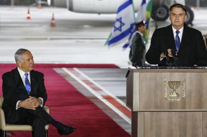 Israeli Prime Minister Benjamin Netanyahu (L) listens to a speech given by Brazilian President Jair Bolsonaro (R) during an official welcome ceremony for Bolsonaro at Tel Aviv Ben Gurion International Airport on March 31, 2019, upon his arrival for his first state visit to Israel. (Photo by Jack GUEZ / AFP)