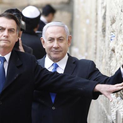 Brazilian President Jair Bolsonaro (foreground) and Israeli Prime Minister Benjamin Netanyahu (background) pray at the Western wall, the holiest site where Jews can pray, in the Old City of Jerusalem on April 1, 2019. - Bolsonaro visited the Western Wall alongside Netanyahu on Monday, becoming the first head of state to do so with an Israeli premier. The site, one of the holiest in Judaism, is located in east Jerusalem, occupied by Israel in the 1967 Six-Day War and later annexed in a move never recognised by the international community. (Photo by Menahem KAHANA / POOL / AFP)