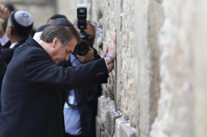 Brazilian President Jair Bolsonaro (foreground) and Israeli Prime Minister Benjamin Netanyahu (background) pray at the Western wall, the holiest site where Jews can pray, in the Old City of Jerusalem on April 1, 2019. - Bolsonaro visited the Western Wall alongside Netanyahu on Monday, becoming the first head of state to do so with an Israeli premier. The site, one of the holiest in Judaism, is located in east Jerusalem, occupied by Israel in the 1967 Six-Day War and later annexed in a move never recognised by the international community. (Photo by Menahem KAHANA / POOL / AFP)