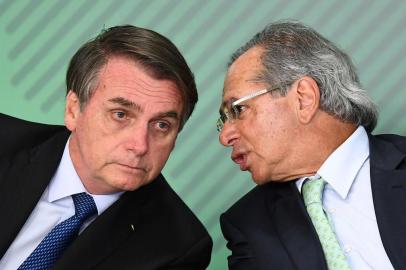  Brazilian President Jair Bolsonaro (L) listens to his Economy Minister Paulo Guedes during a ceremony to sanction of a law that will offer lower bank rates for people who do not have debts, at Planalto Palace in Brasilia, on January 12,  2019. - Brazilian President Jair Bolsonaro on Monday sacked his education minister, an ultraconservative who had drawn public ire over a range of controversial proposals including a revision of school textbooks to deny the 1964 military coup. (Photo by EVARISTO SA / AFP)Editoria: POLLocal: BrasíliaIndexador: EVARISTO SASecao: politics (general)Fonte: AFPFotógrafo: STF