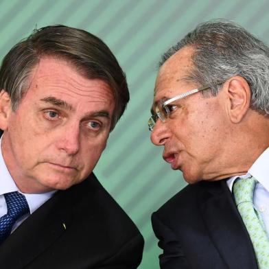  Brazilian President Jair Bolsonaro (L) listens to his Economy Minister Paulo Guedes during a ceremony to sanction of a law that will offer lower bank rates for people who do not have debts, at Planalto Palace in Brasilia, on January 12,  2019. - Brazilian President Jair Bolsonaro on Monday sacked his education minister, an ultraconservative who had drawn public ire over a range of controversial proposals including a revision of school textbooks to deny the 1964 military coup. (Photo by EVARISTO SA / AFP)Editoria: POLLocal: BrasíliaIndexador: EVARISTO SASecao: politics (general)Fonte: AFPFotógrafo: STF