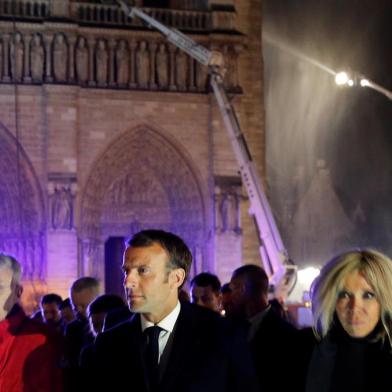  French President Emmanuel Macron and his wife Brigitte walk outside the Notre Dame Cathedral where a fire continues to burn in Paris on April 16, 2019. - A huge fire swept through the roof of the famed Notre-Dame Cathedral in central Paris on April 15, 2019, sending flames and huge clouds of grey smoke billowing into the sky. The flames and smoke plumed from the spire and roof of the gothic cathedral, visited by millions of people a year. A spokesman for the cathedral told AFP that the wooden structure supporting the roof was being gutted by the blaze. (Photo by PHILIPPE WOJAZER / POOL / AFP)Editoria: LIFLocal: ParisIndexador: PHILIPPE WOJAZERSecao: tourismFonte: POOLFotógrafo: STR