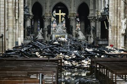  A picture taken on April 16, 2019 shows the altar surrounded by charred debris inside the Notre-Dame Cathedral in Paris in the aftermath of a fire that devastated the cathedral. - French investigators probing the devastating blaze at Notre-Dame Cathedral on April 15, 2019, questioned workers who were renovating the monument on April 16, as hundreds of millions of euros were pledged to restore the historic masterpiece. As firefighters put out the last smouldering embers, a host of French billionaires and companies stepped forward with offers of cash worth around 600 million euros ($680 million) to remake the iconic structure. (Photo by LUDOVIC MARIN / AFP)Editoria: DISLocal: ParisIndexador: LUDOVIC MARINSecao: fireFonte: AFPFotógrafo: STF