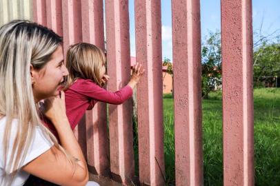  PORTO ALEGRE, RS, BRASIL, 17/04/2019: Mães com filhos que estão na fila por vaga em creche.  Gilviane Gawlinki, com a filha Maria Eduarda no muro da Emei Vila Nova Restinga. (Foto: Omar Freitas / Agência RBS)